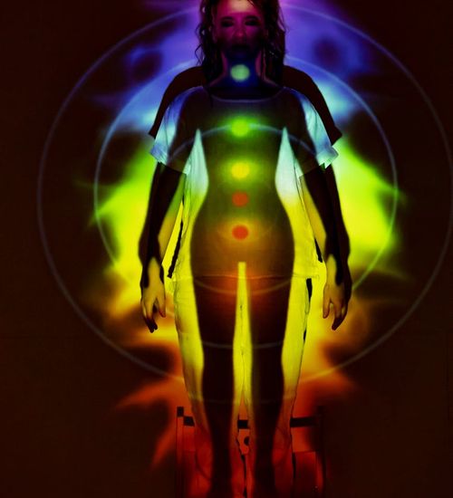 Silhouette of a person in a powerful yoga pose, radiating fuchsia energy against a dark sky.